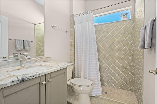 full bath with toilet, tile patterned flooring, a tile shower, and vanity