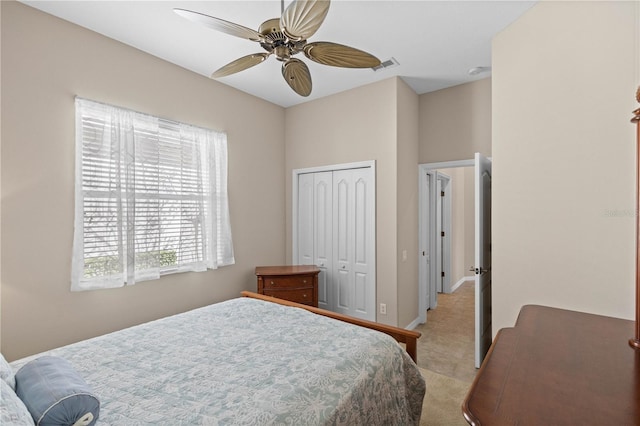 bedroom featuring baseboards, visible vents, a ceiling fan, light colored carpet, and a closet