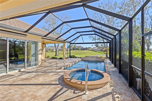 outdoor pool with an in ground hot tub, a yard, a patio area, and glass enclosure