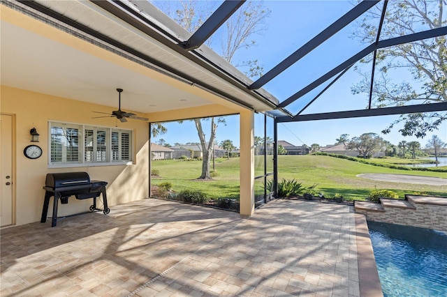 view of patio featuring glass enclosure, ceiling fan, and a grill