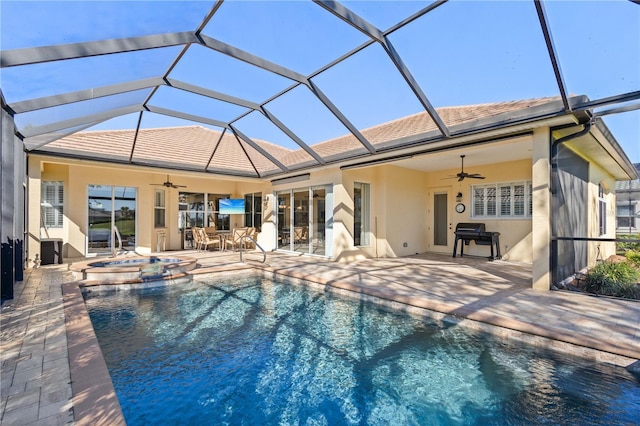 view of swimming pool featuring a pool with connected hot tub, a patio, a lanai, and ceiling fan