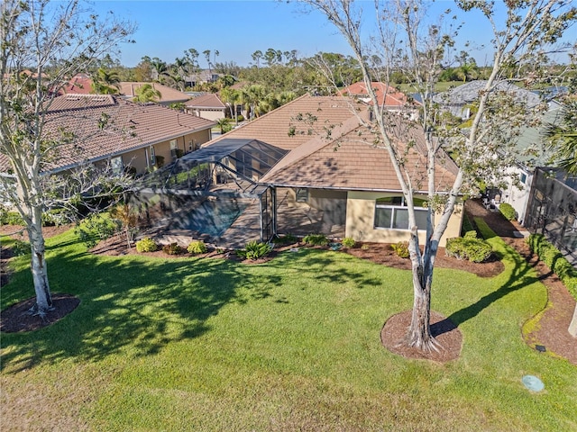 view of front of home with a lanai, a front lawn, and a tiled roof