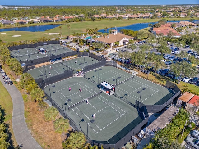 drone / aerial view with a residential view, a water view, and golf course view