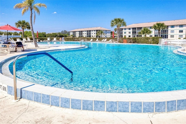 community pool with fence and a patio