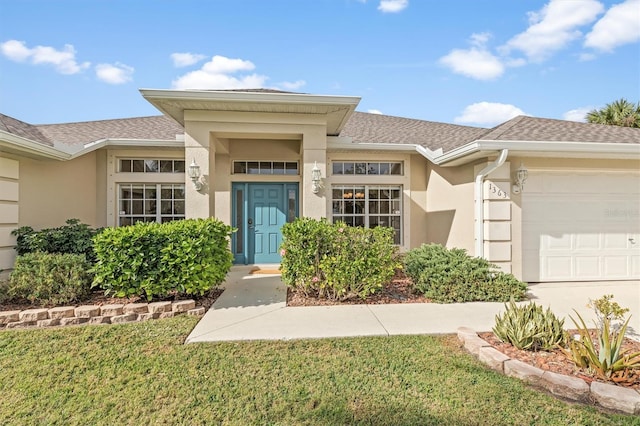 entrance to property with a garage, roof with shingles, and stucco siding