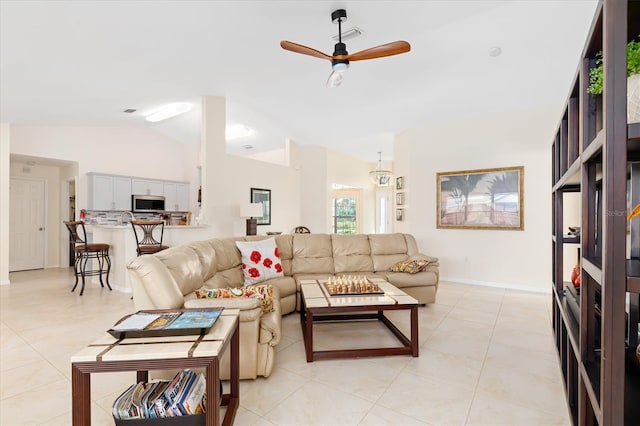 living room featuring lofted ceiling, light tile patterned floors, and a ceiling fan