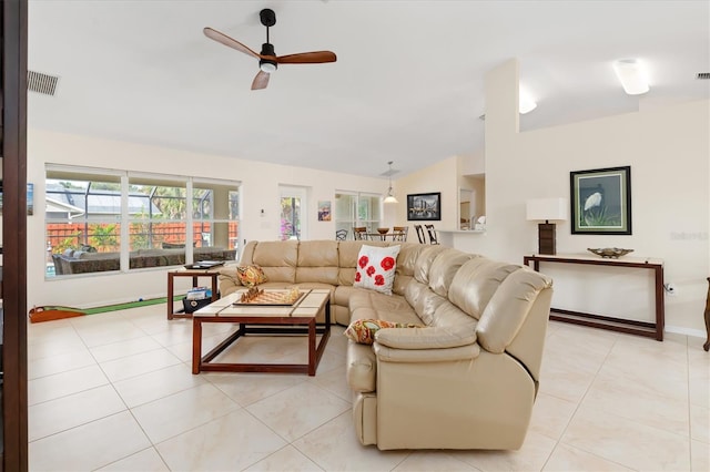 living room featuring light tile patterned floors, visible vents, ceiling fan, vaulted ceiling, and baseboards