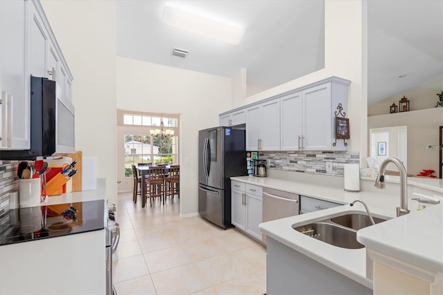 kitchen featuring stainless steel appliances, visible vents, decorative backsplash, light tile patterned flooring, and a sink