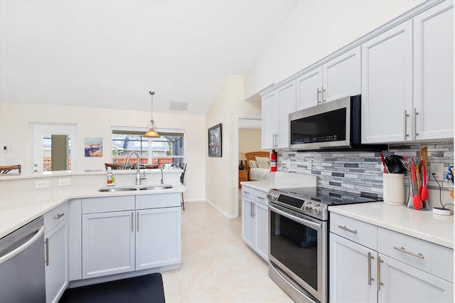 kitchen featuring backsplash, stainless steel appliances, a sink, and light countertops