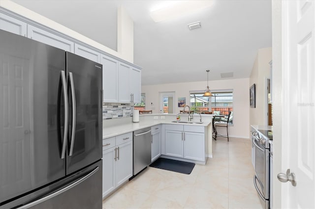 kitchen with stainless steel appliances, a peninsula, a sink, visible vents, and light countertops