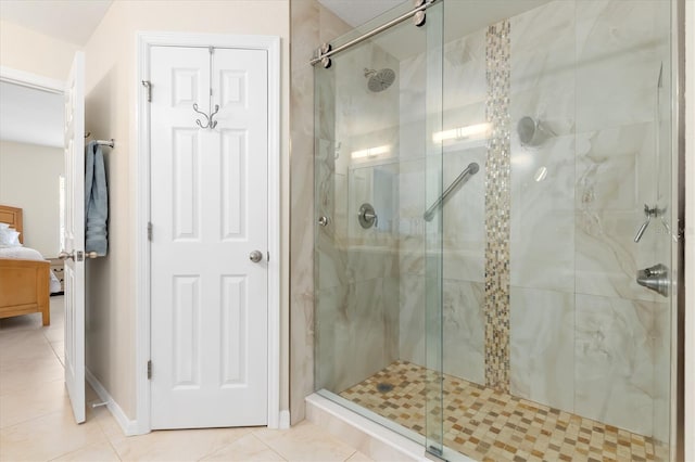 bathroom featuring baseboards, ensuite bath, a shower stall, and tile patterned floors