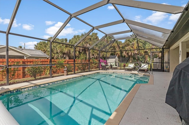 view of pool with glass enclosure, a patio area, fence, and a fenced in pool