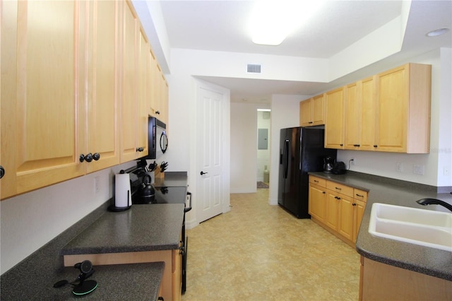 kitchen with dark countertops, visible vents, light brown cabinets, a sink, and black appliances