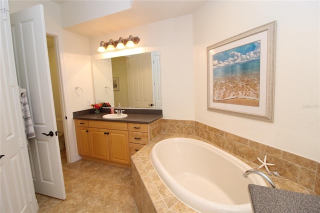 bathroom featuring a garden tub, vanity, and toilet