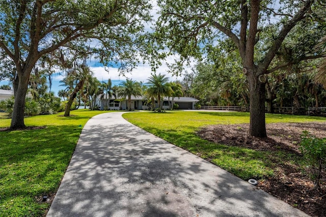 view of home's community featuring a lawn and fence