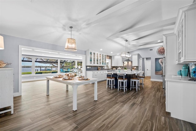 kitchen with light countertops, a center island, dark wood finished floors, and white cabinets