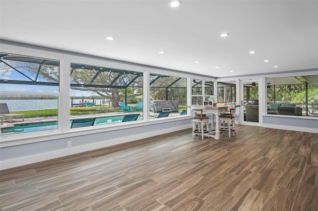 unfurnished sunroom featuring a water view and a wealth of natural light