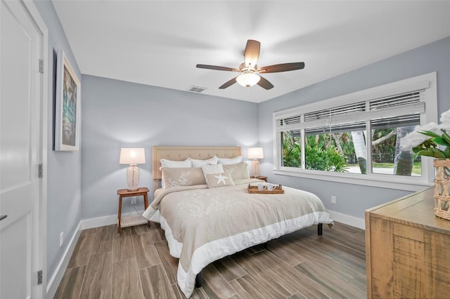 bedroom featuring ceiling fan, wood finish floors, visible vents, and baseboards