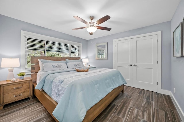 bedroom with wood finish floors, a closet, ceiling fan, and baseboards