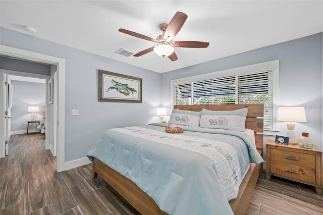 bedroom with visible vents, ceiling fan, baseboards, and wood finished floors