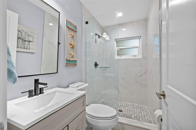 full bath featuring toilet, a tile shower, and vanity