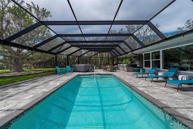 pool with a patio, outdoor lounge area, glass enclosure, and a hot tub