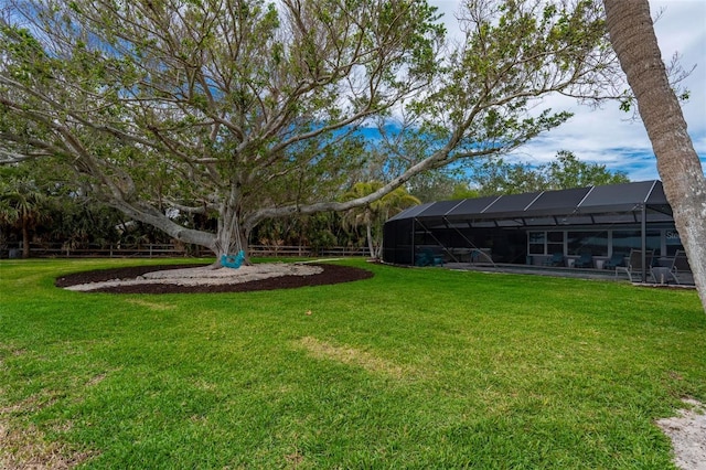 view of yard featuring glass enclosure and fence