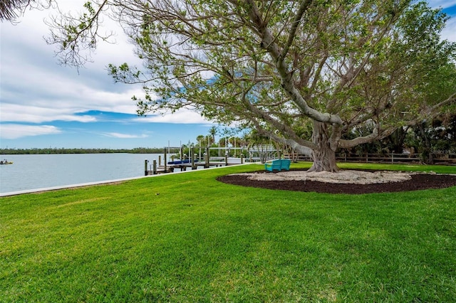 view of dock featuring a yard, a water view, and boat lift