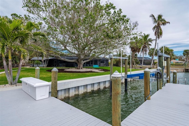 dock area with a lawn and a water view