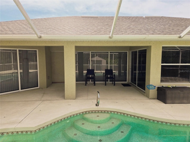 pool with glass enclosure and a patio