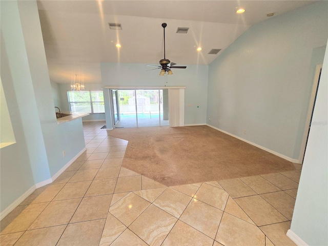 empty room featuring light carpet, vaulted ceiling, visible vents, and light tile patterned floors