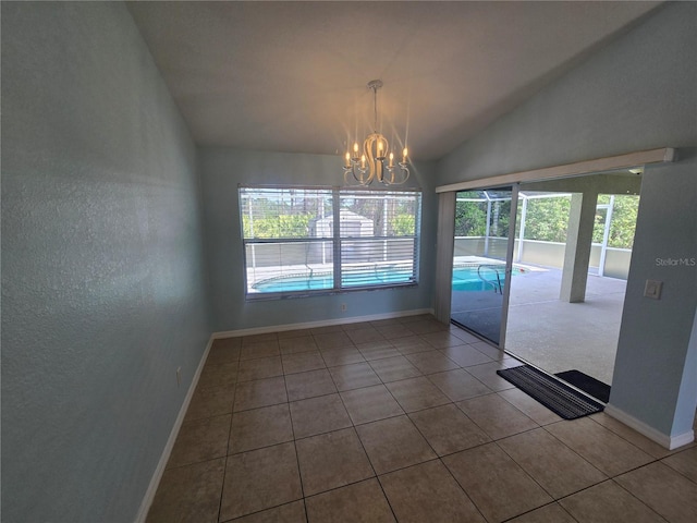 empty room with vaulted ceiling, baseboards, tile patterned flooring, and an inviting chandelier