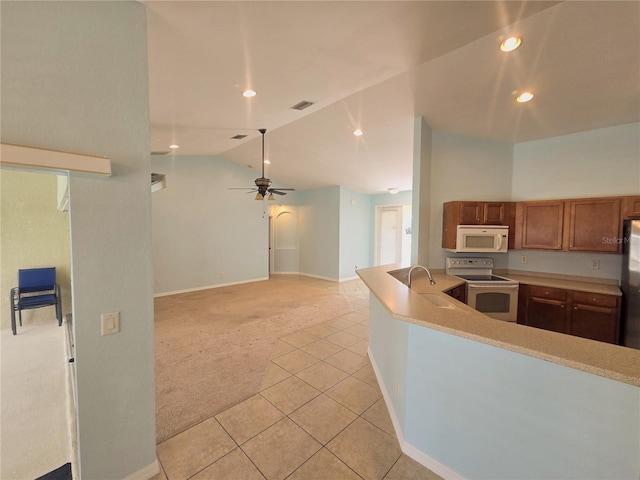 kitchen with lofted ceiling, light colored carpet, white appliances, a sink, and light countertops