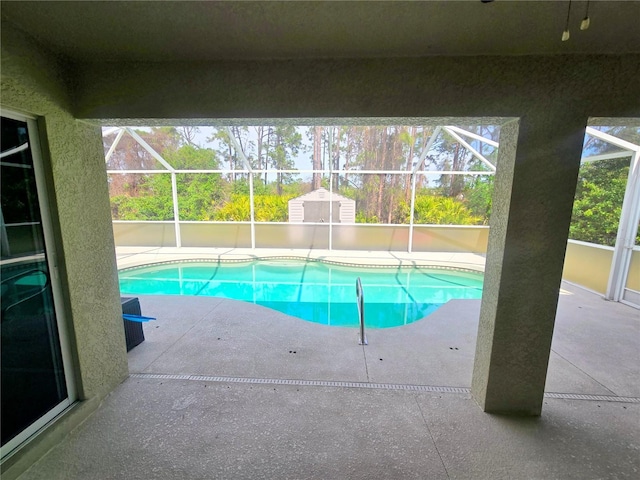 pool featuring glass enclosure and a patio