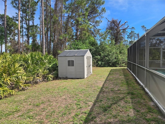 view of yard featuring glass enclosure, a shed, and an outdoor structure