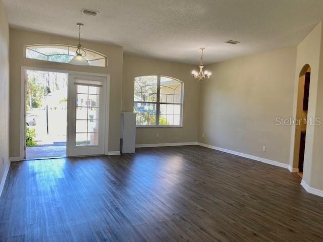 interior space with dark wood-style floors, visible vents, and an inviting chandelier