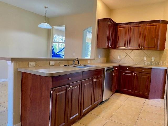 kitchen with stainless steel dishwasher, light countertops, a peninsula, and a sink