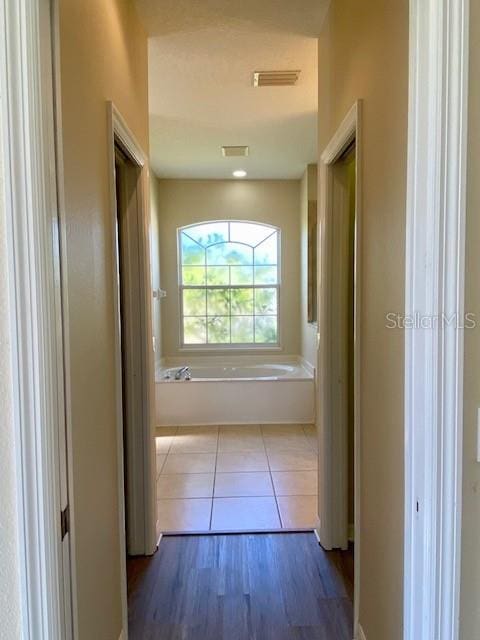 hallway with tile patterned floors and visible vents