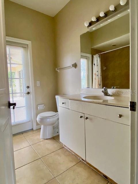 full bathroom featuring vanity, tile patterned floors, toilet, and a shower with curtain