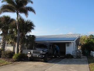 exterior space with a carport, driveway, and metal roof