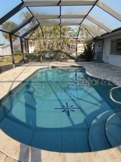 pool with glass enclosure and a patio