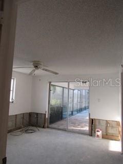 empty room with a textured ceiling and ceiling fan