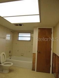 bathroom with toilet and shower / bathing tub combination