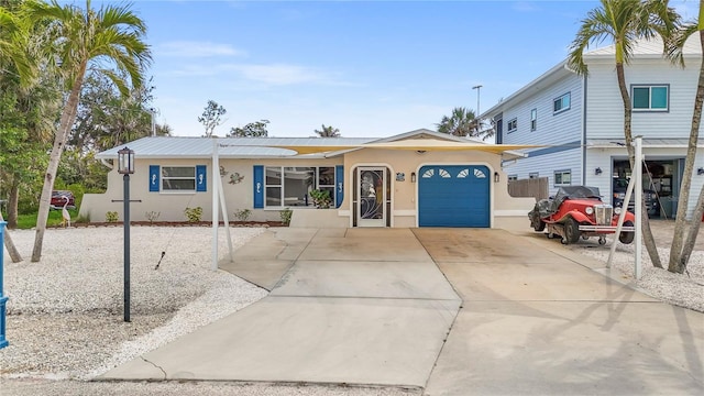 ranch-style house with a garage, driveway, and stucco siding