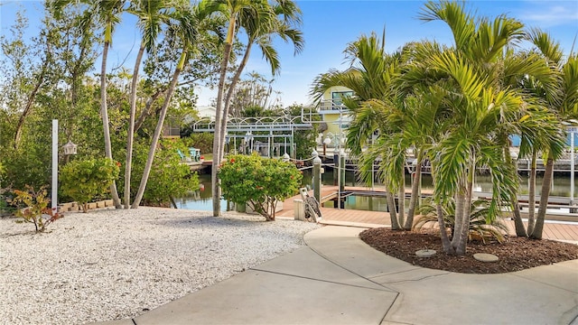 view of community featuring a water view, a boat dock, and boat lift