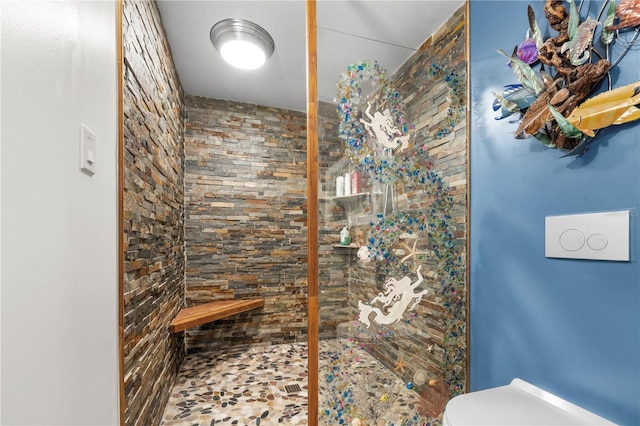 bathroom featuring tiled shower and toilet