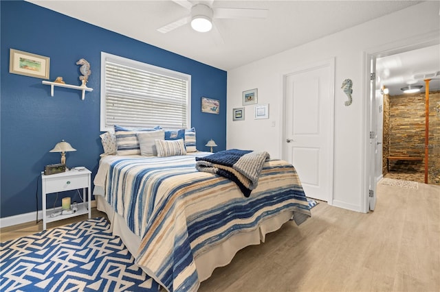 bedroom featuring ceiling fan, wood finished floors, visible vents, and baseboards