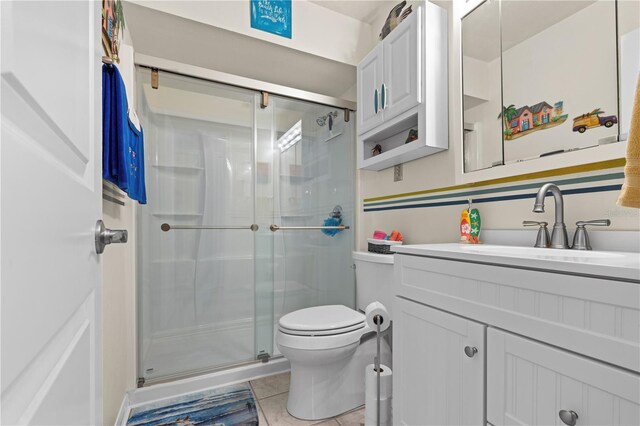 full bath with toilet, a stall shower, tile patterned flooring, and vanity