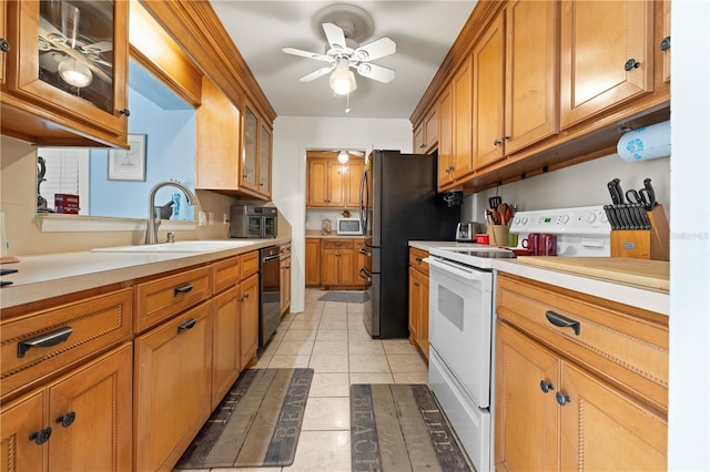 kitchen with black dishwasher, electric range, brown cabinets, light countertops, and a sink