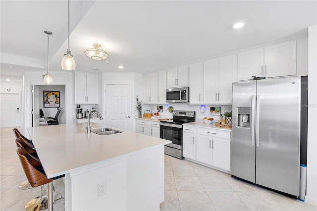 kitchen featuring appliances with stainless steel finishes, light tile patterned flooring, a sink, and white cabinetry